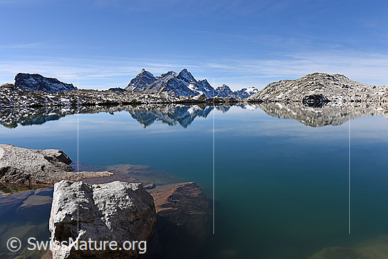 Foto: Spiegelung einer kargen Berglandschaft in Bergsee.