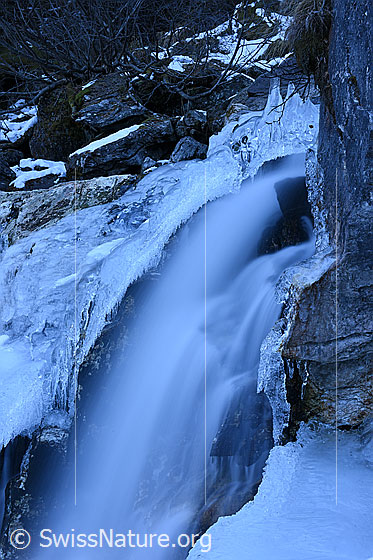 Foto: Von Eisgebilden gesäumter Wasserfall.