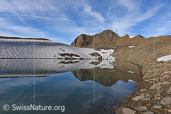 Foto: Spiegelung einer kargen Berglandschaft in Bergsee.
