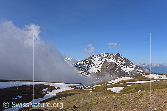 Foto: Wolkenstimmung am Breithorn mit Ausblick über einen kargen Bergrücken zum Bättlihorn.