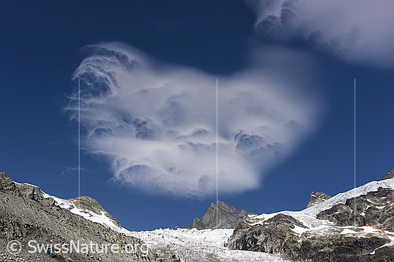 Foto: Wolkenbild über Berglandschaft. Die lustige Wolkenerscheinung gleicht einem Hundegesicht.