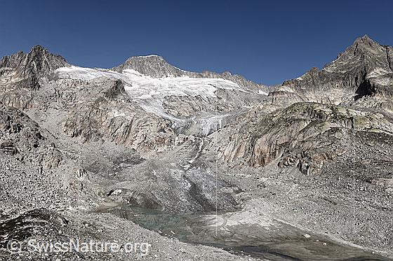 Foto: Tiefengletscher, Urner Alpen. 
Die Gletscherzunge endet in einem sandigen Gletschervorfeld mit Gletschersee. Im Hintergrund sind Gross Bielenhorn, Galenstock und Gletschhorn zu sehen.
