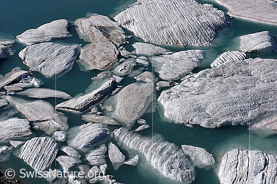 Foto: Geschichtete Eisschollen treiben in Gletschersee.