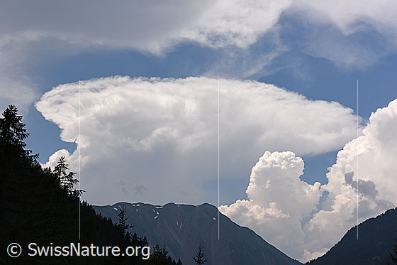 Foto: Ambosswolke (Cumulonimbus) über einem Berggipfel. Die Ambosswolke gilt als Gewitterwolke.