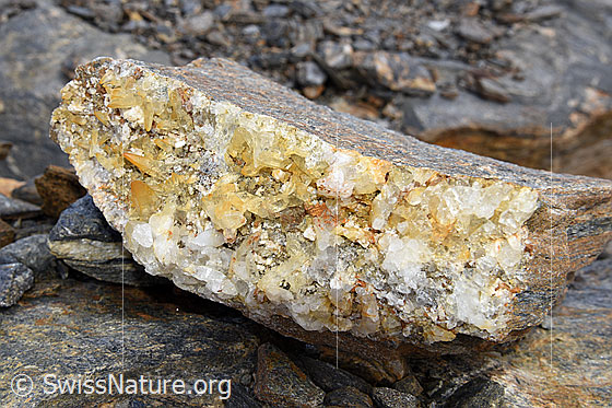 Foto: Ca. 20cm breites Stück einer Kluftwand aus einer Zerrkluft, an welcher Bergkristalle wachsen konnten.
