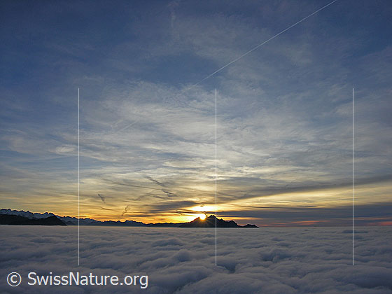 Foto: Sonnenuntergang mit Silhouette des Pilatus und kompaktem Nebelmeer. Im Horizont ist die Bergkette der Berner Alpen und davor das Stanserhorn erkennbar.