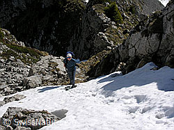 F022816: Alpinistin am Fuss eines Couloirs mit Schneefeld