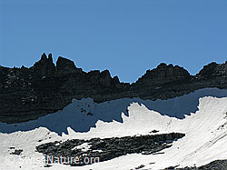 Foto: Spiegelbild eines Felsgrats als Schatten im Schnee