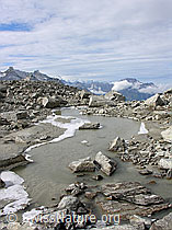 F030267: Ruhiger Bergbach mit gefrorenem Ufer verläuft zwischen Felsblöcken