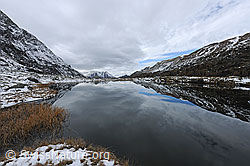 F122273: Spiegelung einer leicht verschneiten Berglandschaft in Bergsee