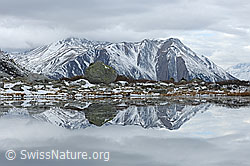 F122303: Spiegelung einer leicht verschneiten Berglandschaft in Bergsee
