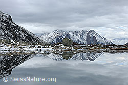 F122305: Spiegelung einer leicht verschneiten Naturlandschaft in Bergsee